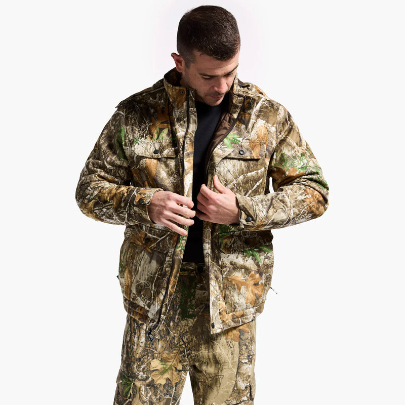 Man wearing a camouflage hunting jacket and pants on a white background