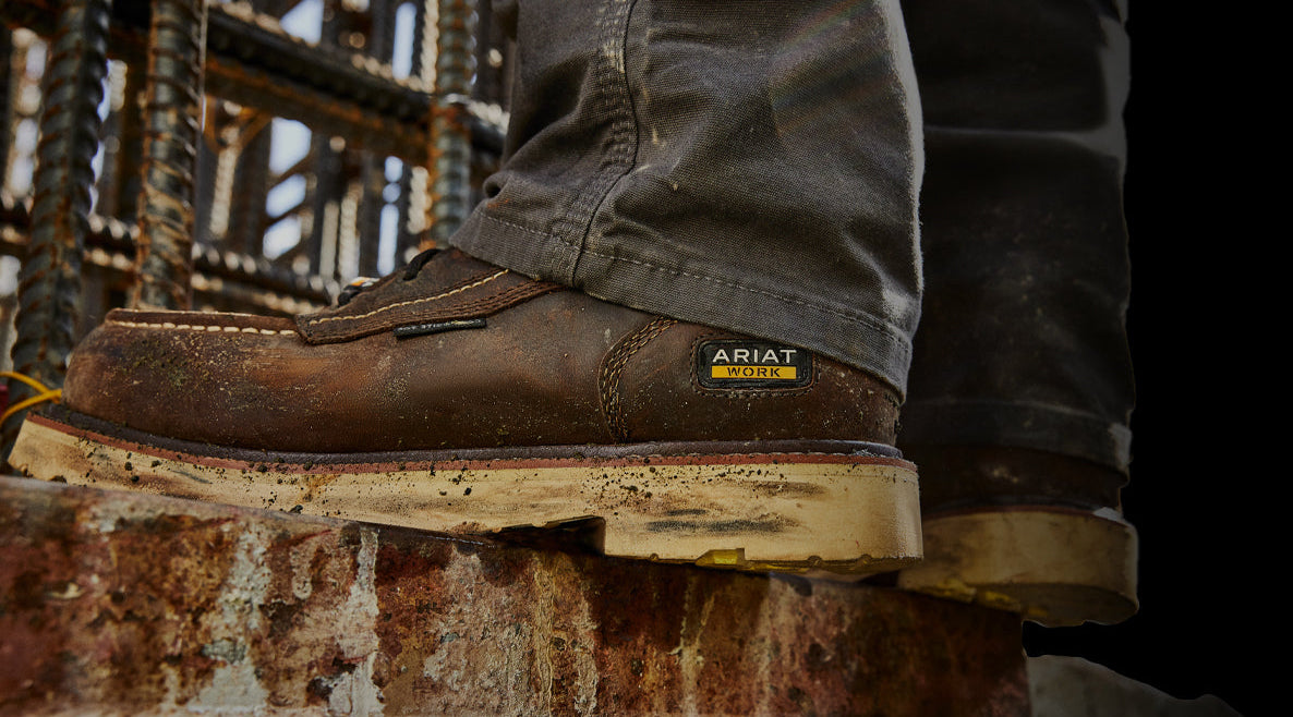 Brown work boot with Ariat logo on a rustic background