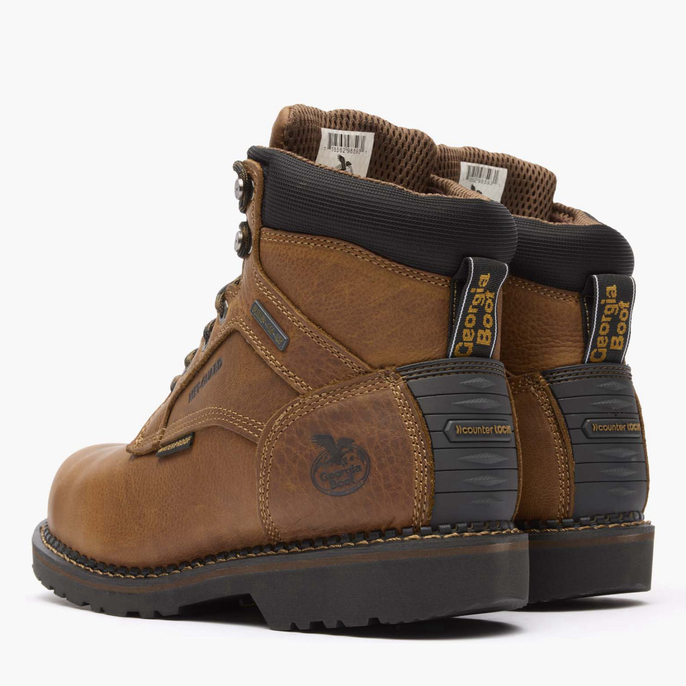 Pair of brown work boots with black soles on a white background