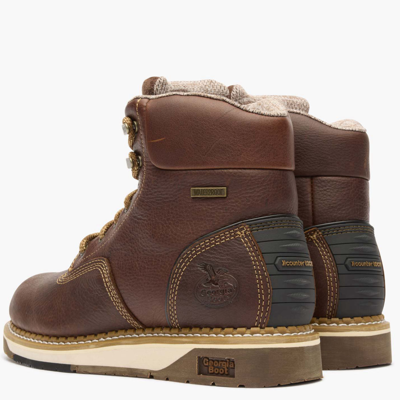 Pair of brown leather boots with visible branding on a white background