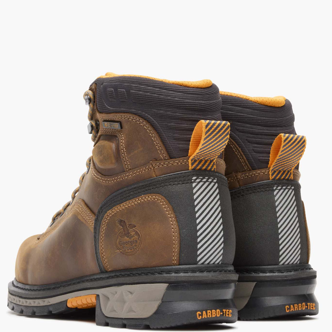 Pair of brown and black work boots with orange accents on a white background