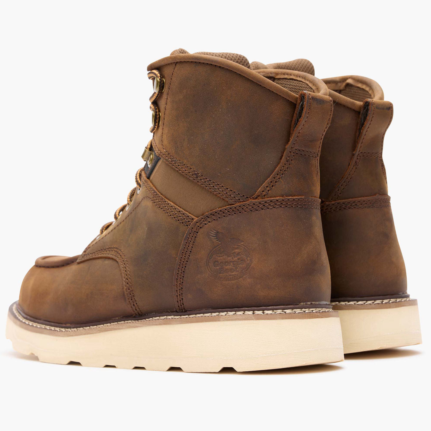 Pair of brown leather boots with a white sole on a white background