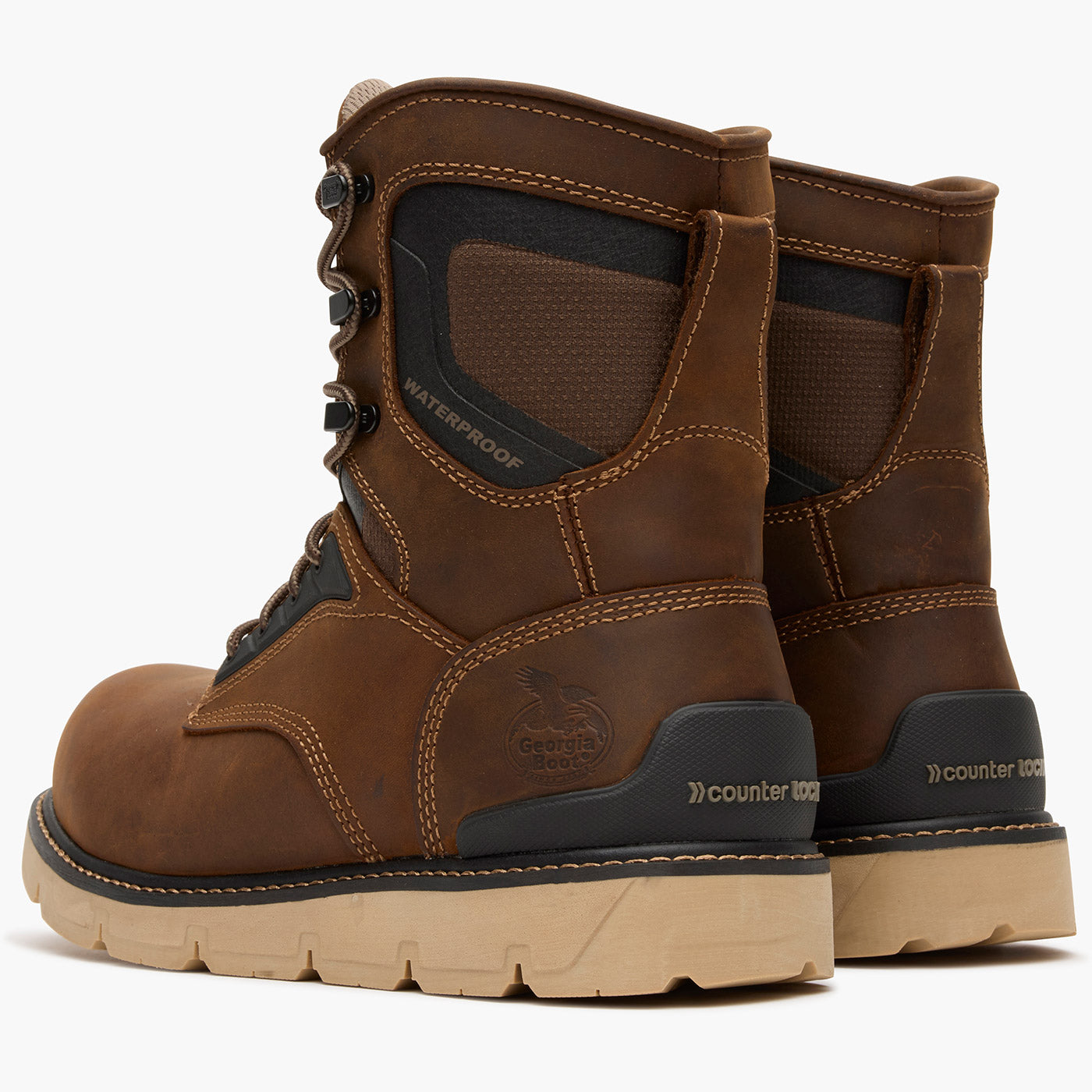 Pair of brown work boots with black accents on a white background