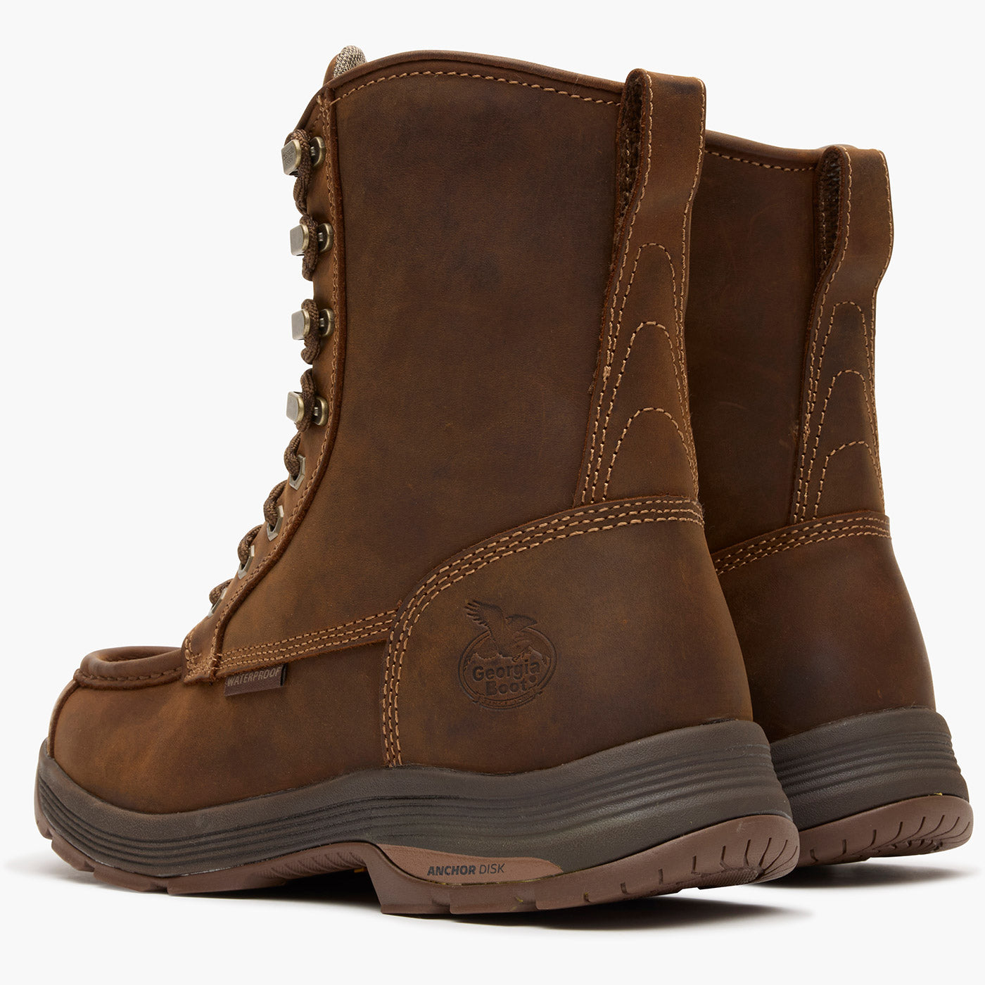 Pair of brown leather boots with a visible brand logo on a white background
