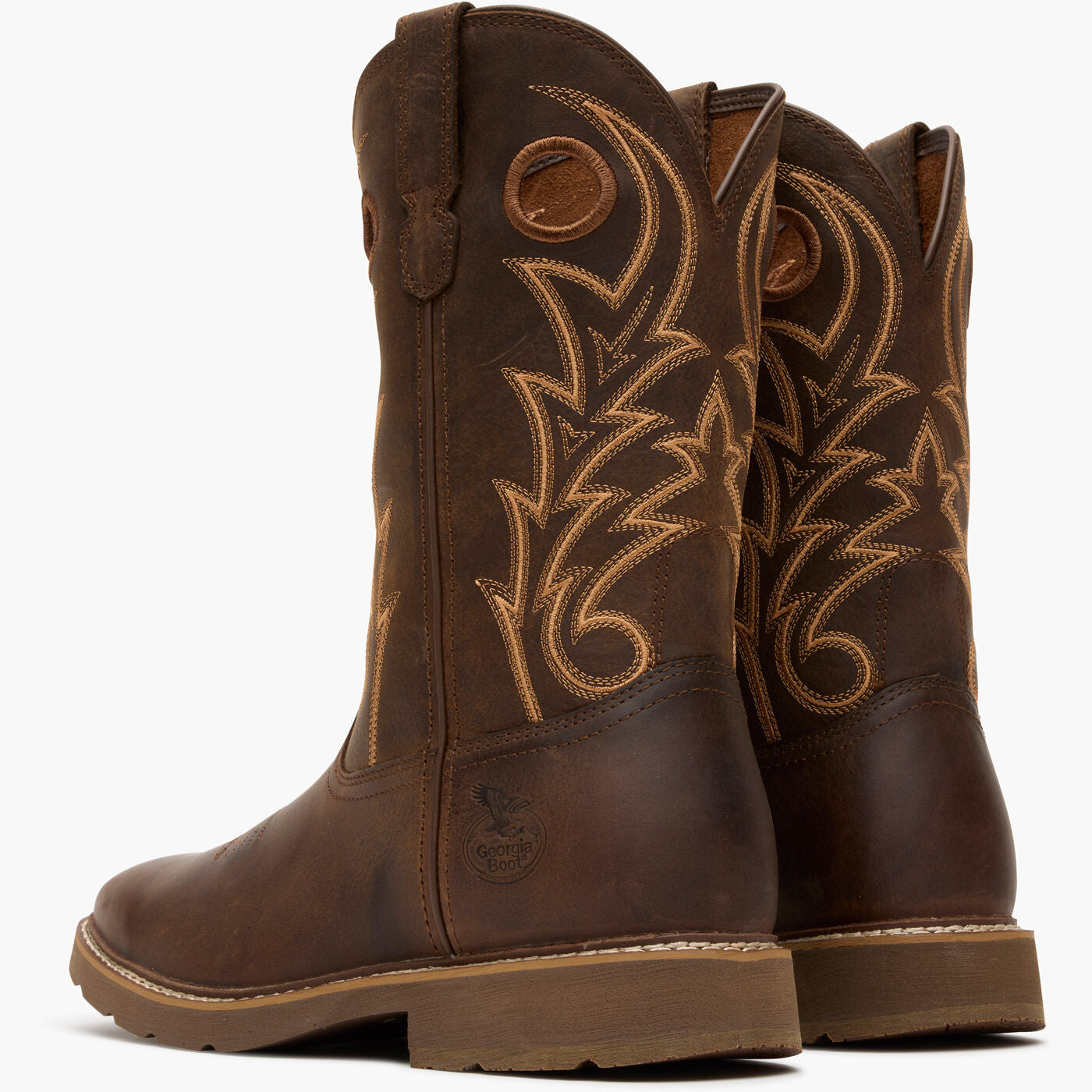 Pair of brown cowboy boots with intricate stitching on a white background