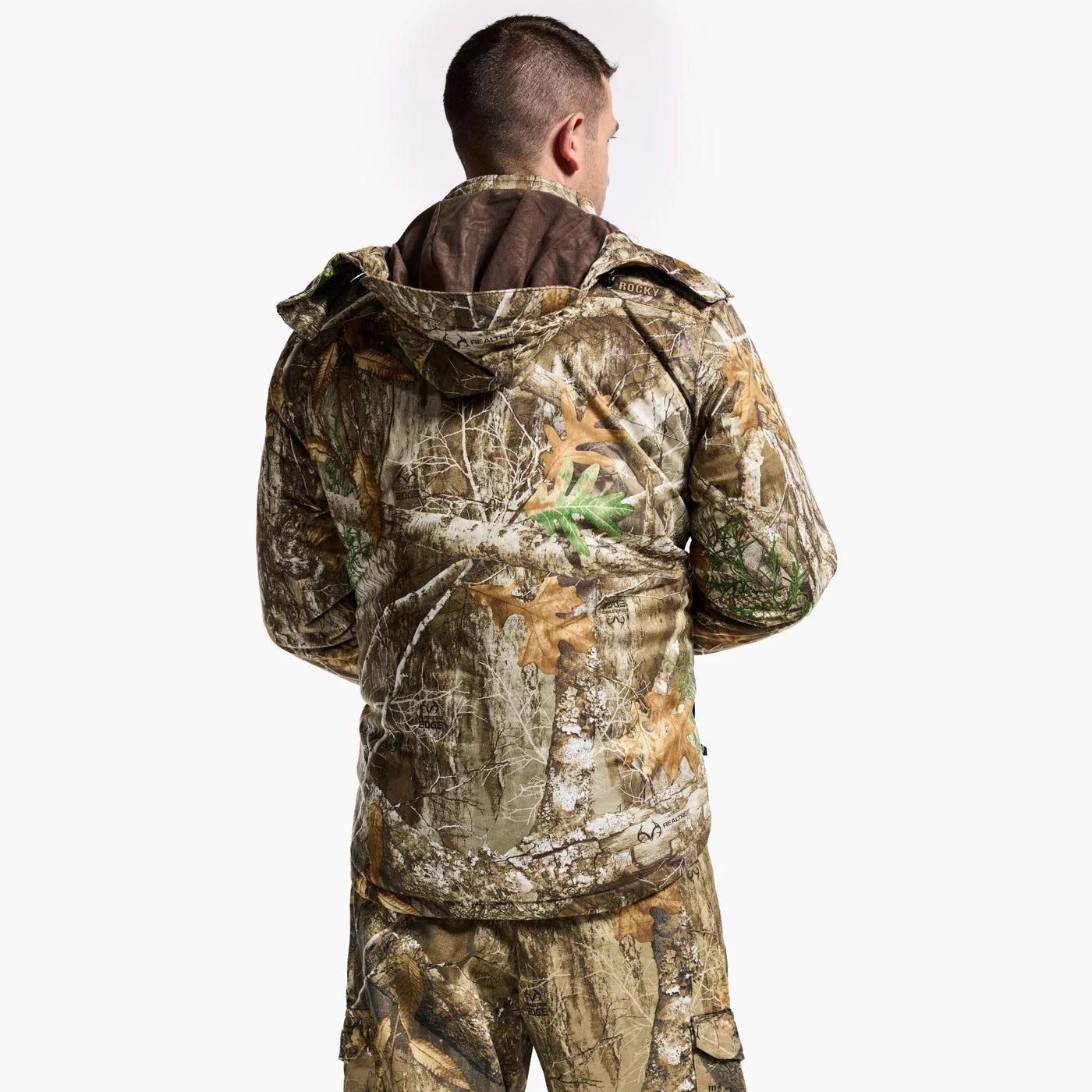 Person wearing a camouflage jacket and pants on a white background