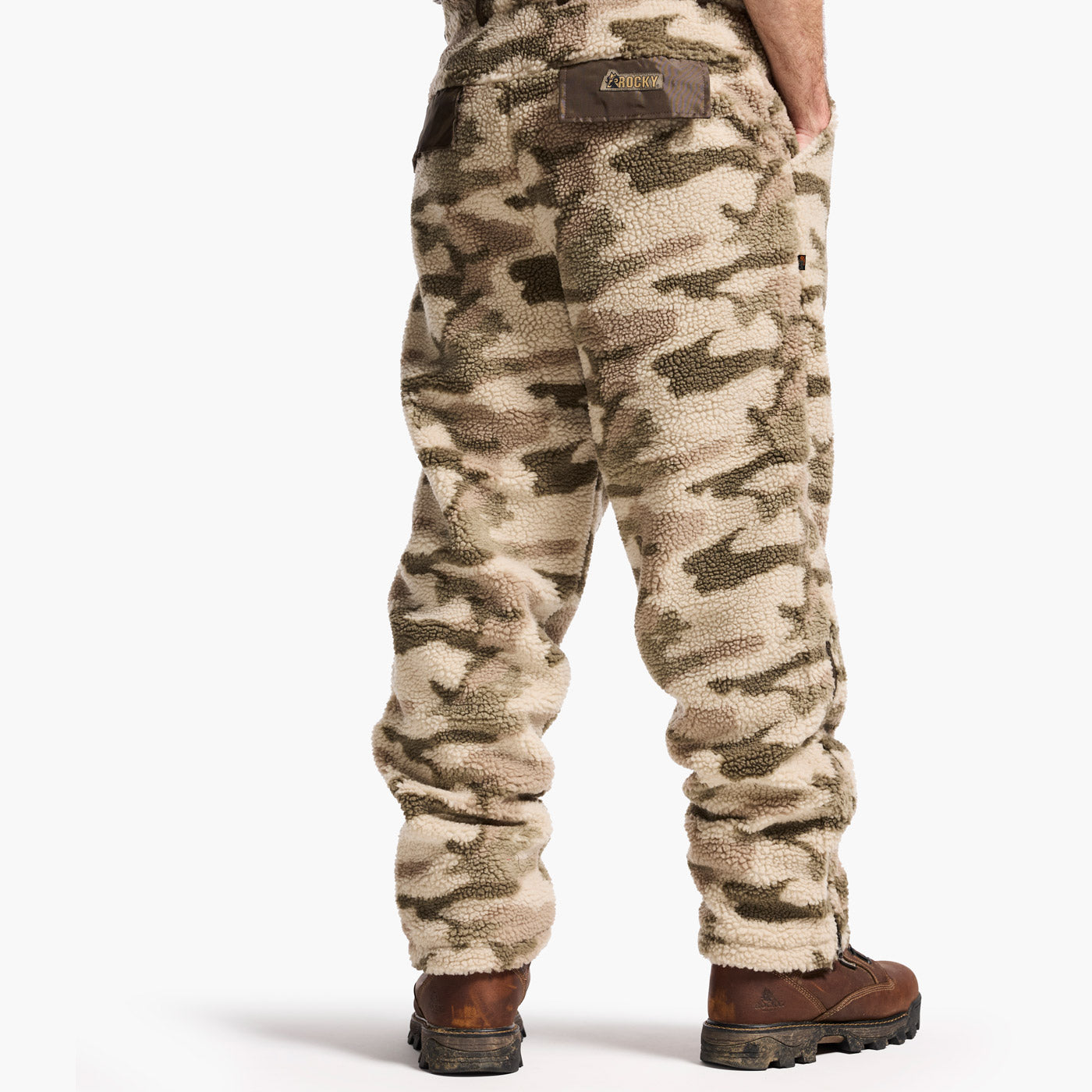 Camouflage pants worn by a person on a white background