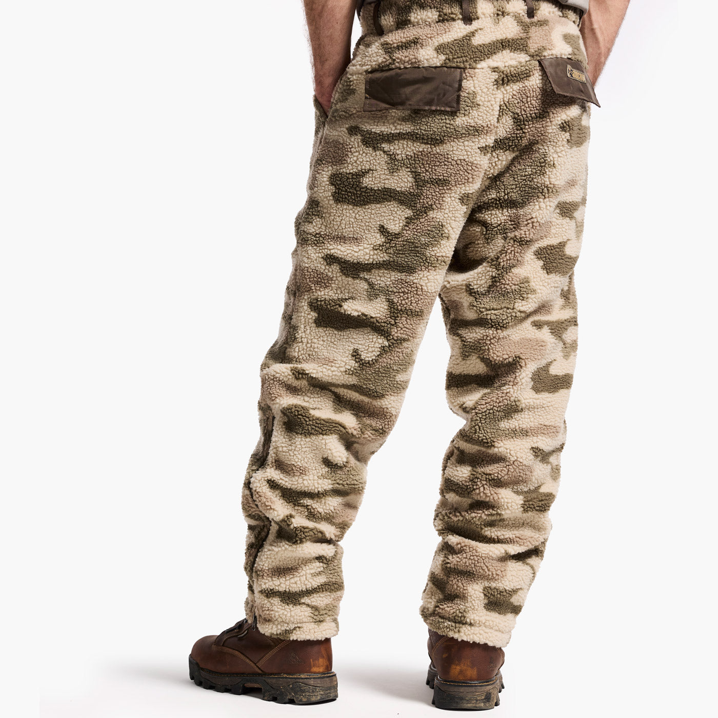 Camouflage pants worn by a person on a white background