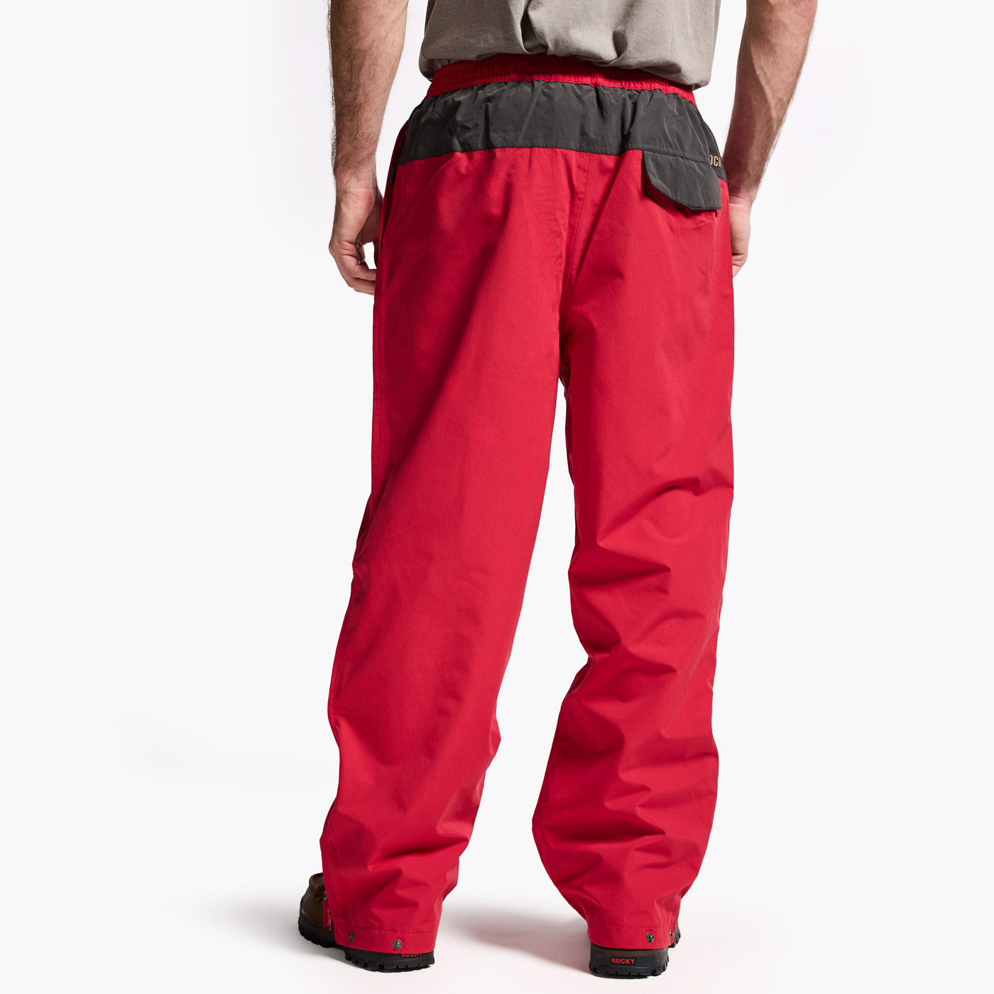 Red snow pants with black accents worn by a person on a white background