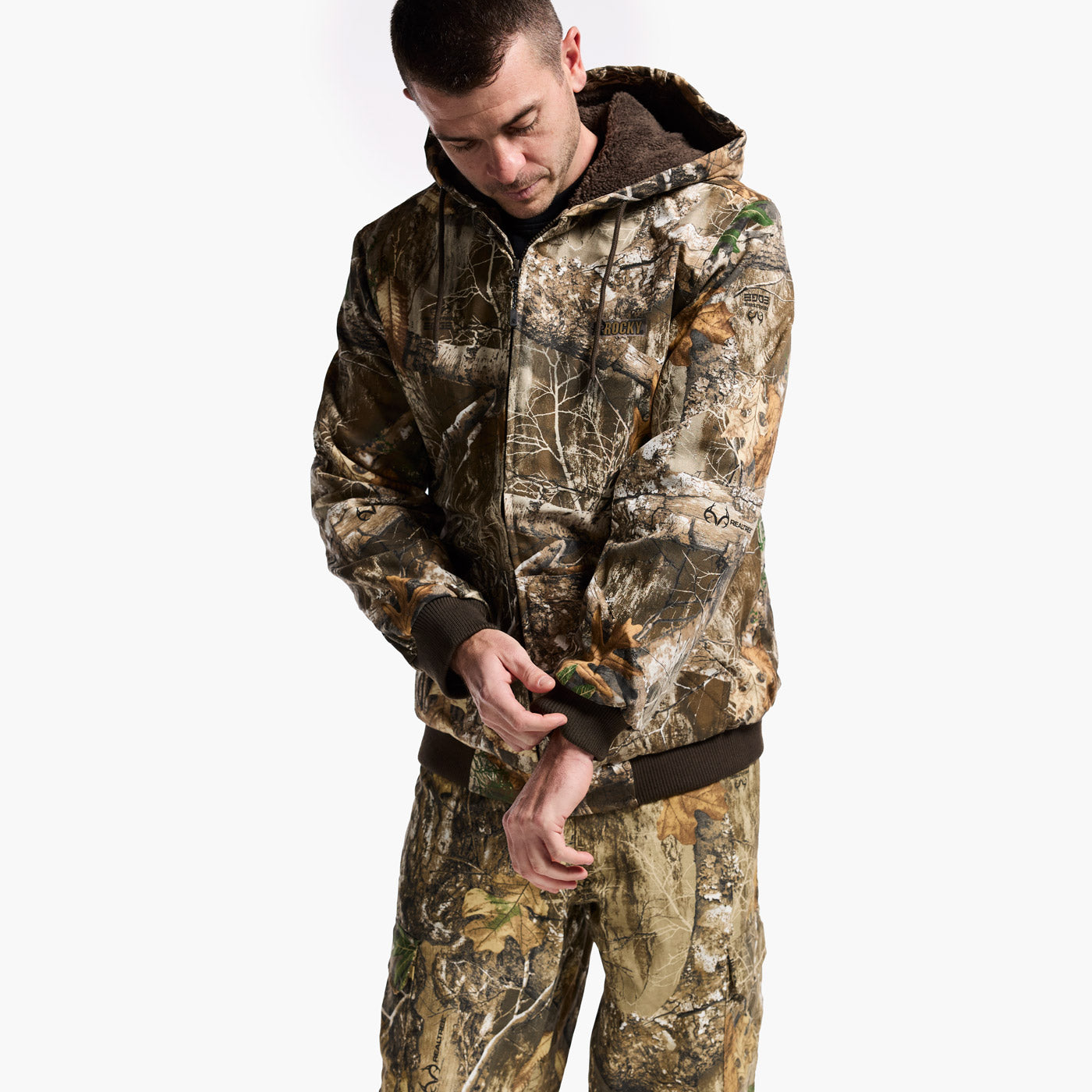 Man wearing a full camouflage outfit on a white background