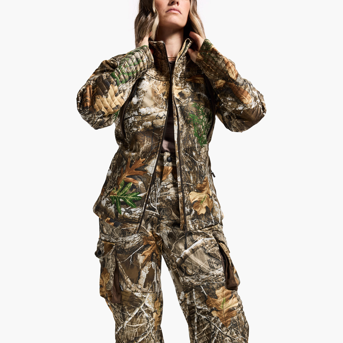 Person wearing a camouflage hunting suit on a white background