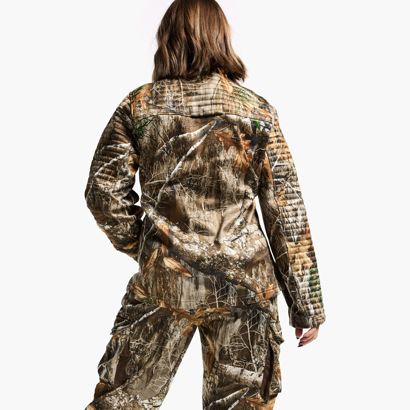 Person wearing a camouflage jacket and pants on a white background