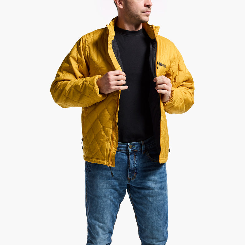 Man wearing a yellow quilted jacket and blue jeans on a white background