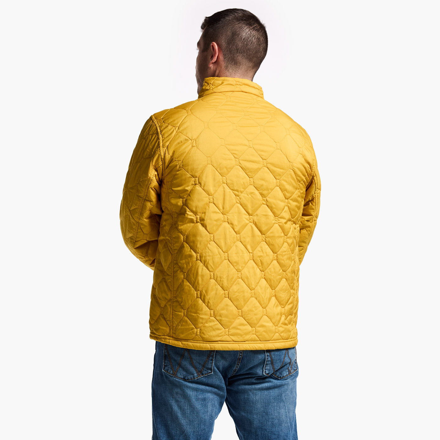 Man wearing a yellow quilted jacket on a white background