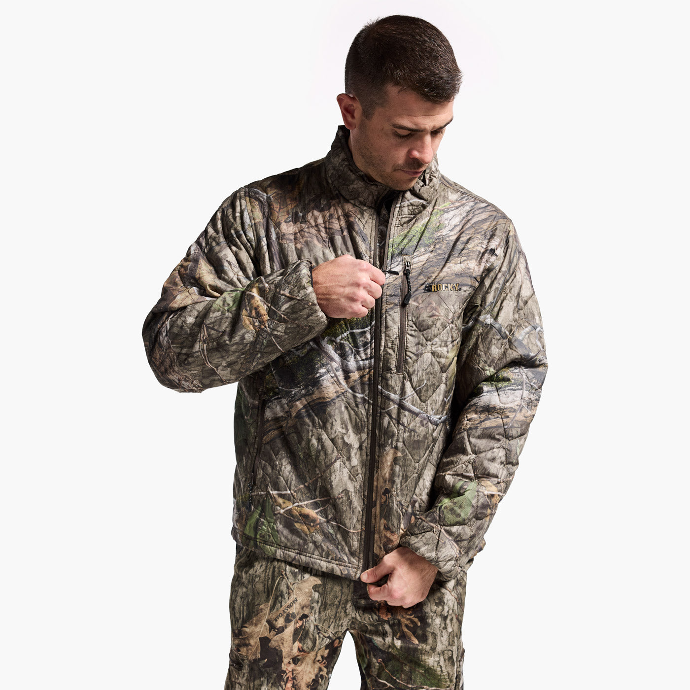 Man wearing a camouflage jacket and pants on a white background