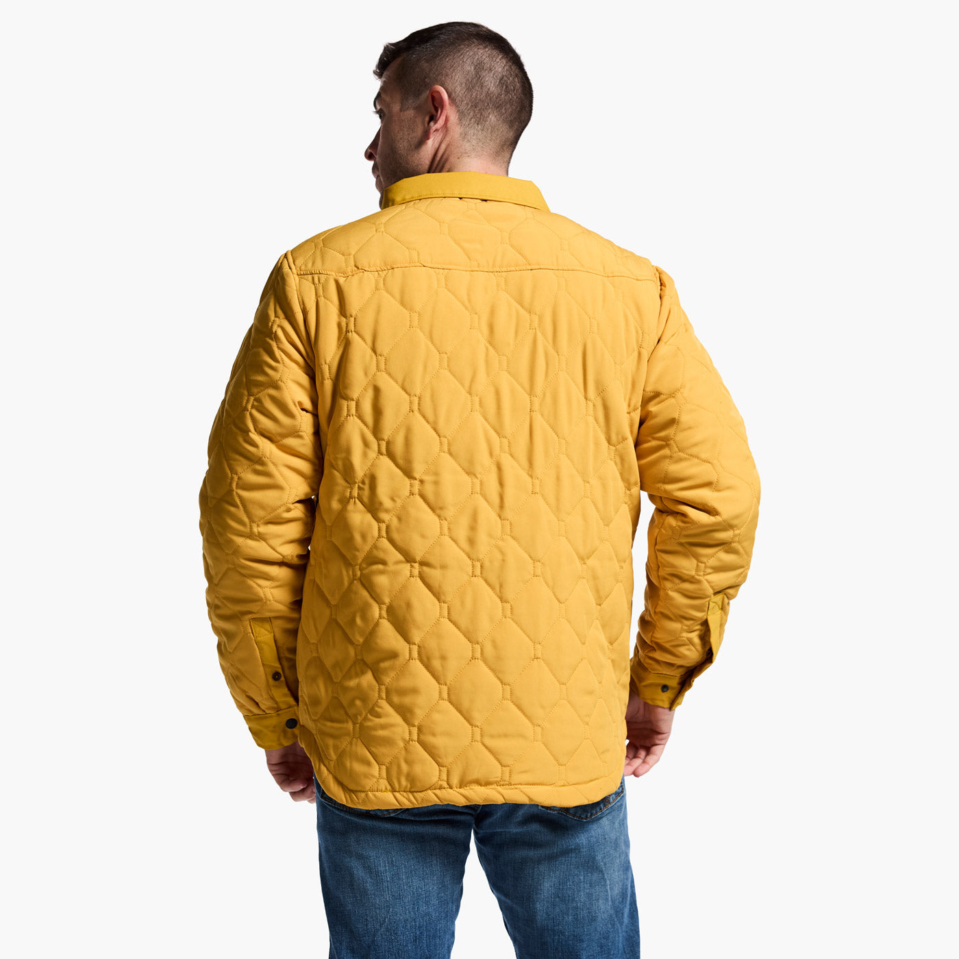 Man wearing a yellow quilted jacket on a white background