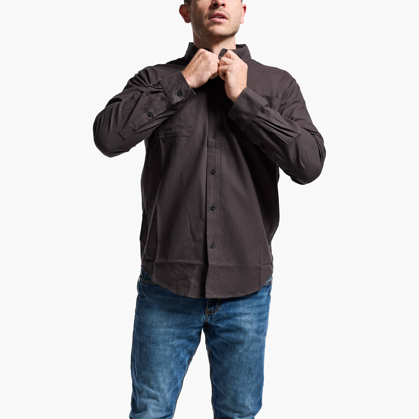 Man wearing a dark brown button-up shirt and blue jeans on a white background