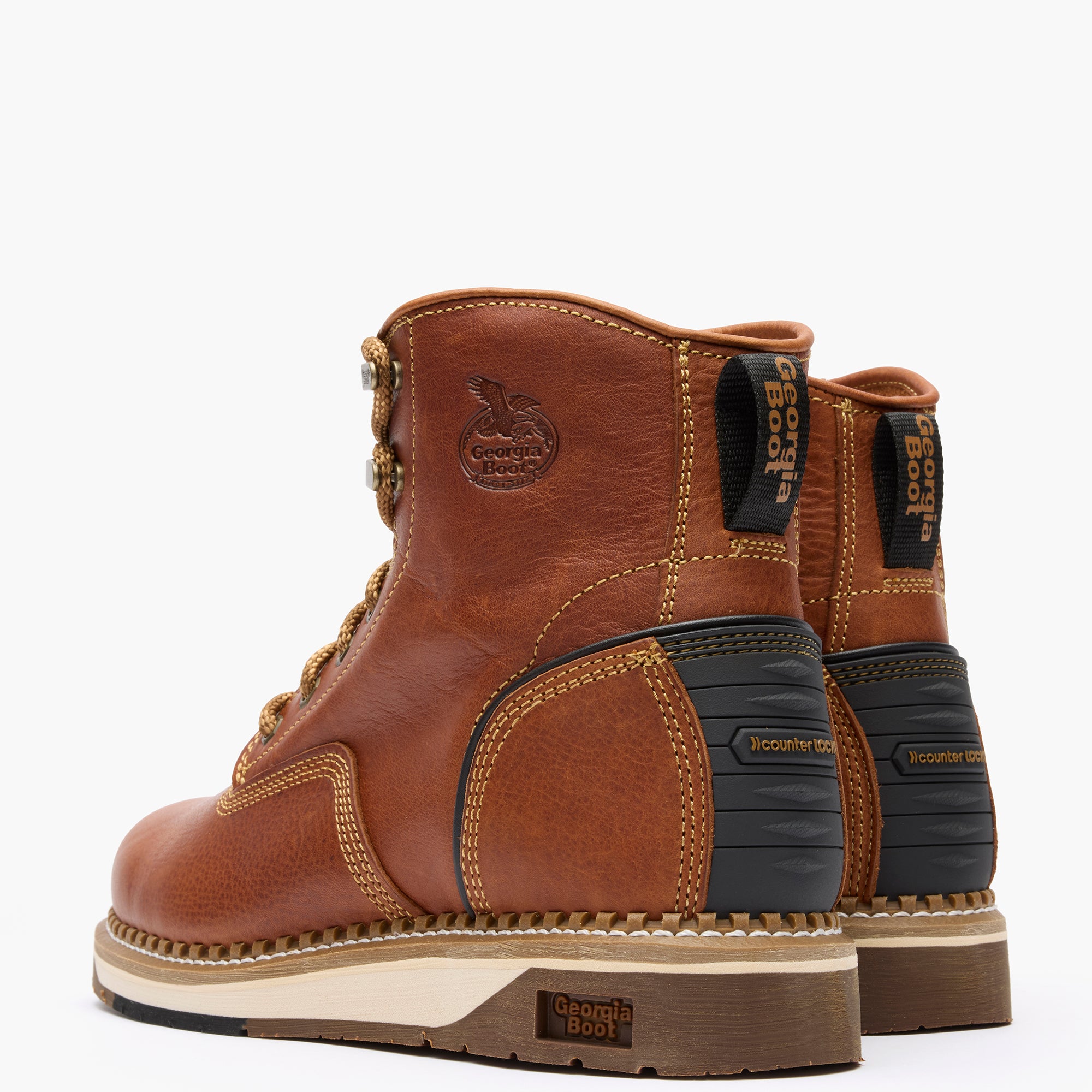 Pair of brown leather boots with black soles on a white background