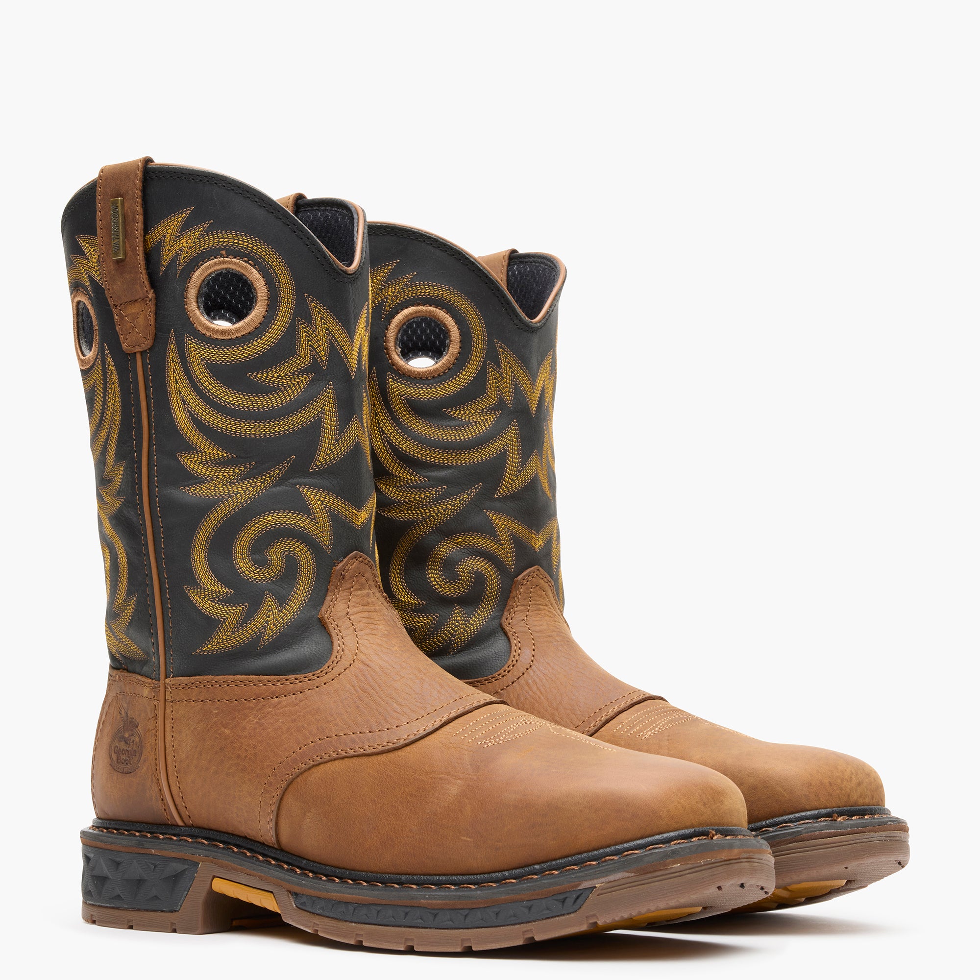 Pair of brown and black cowboy boots with intricate patterns on a white background