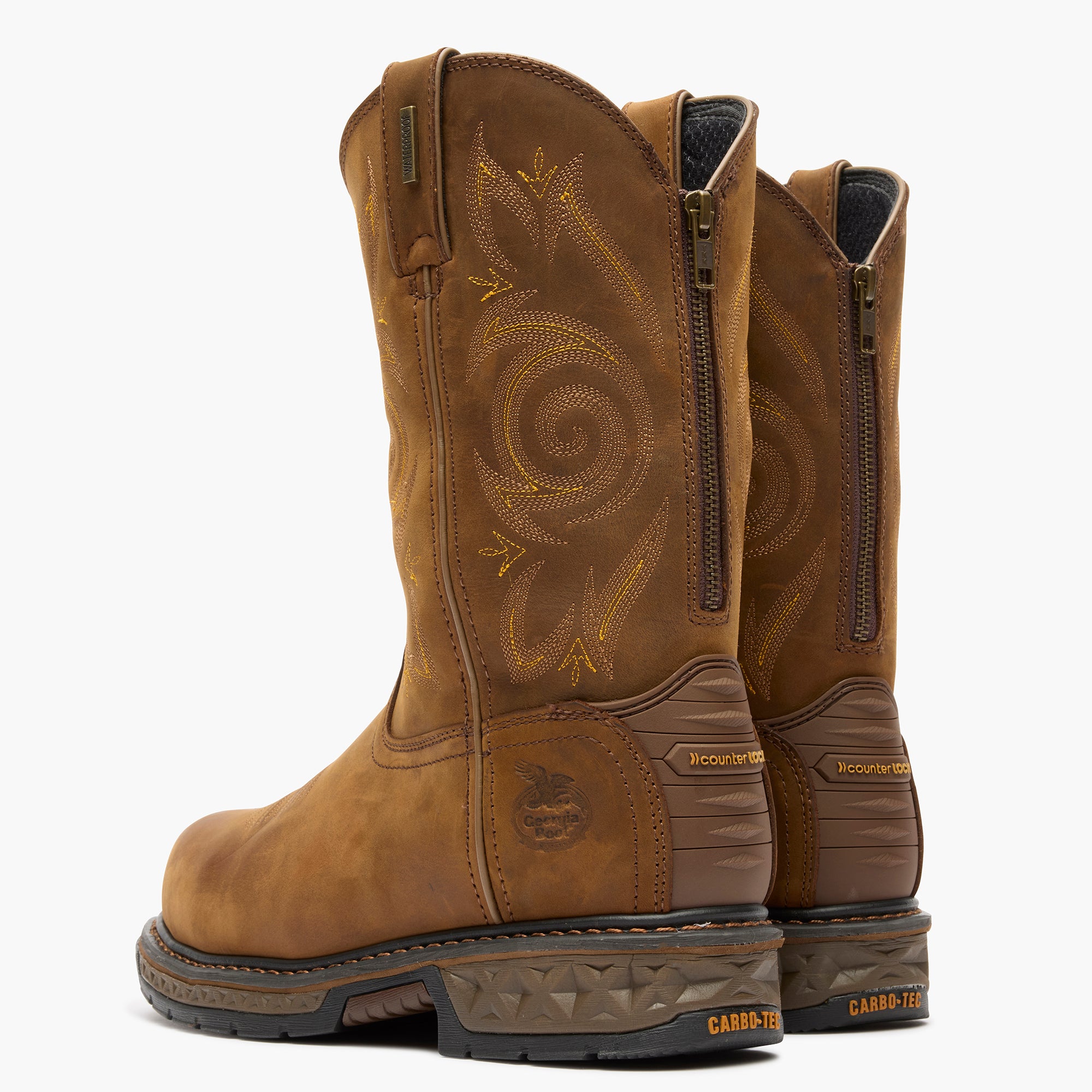 Pair of brown leather boots with intricate designs on a white background