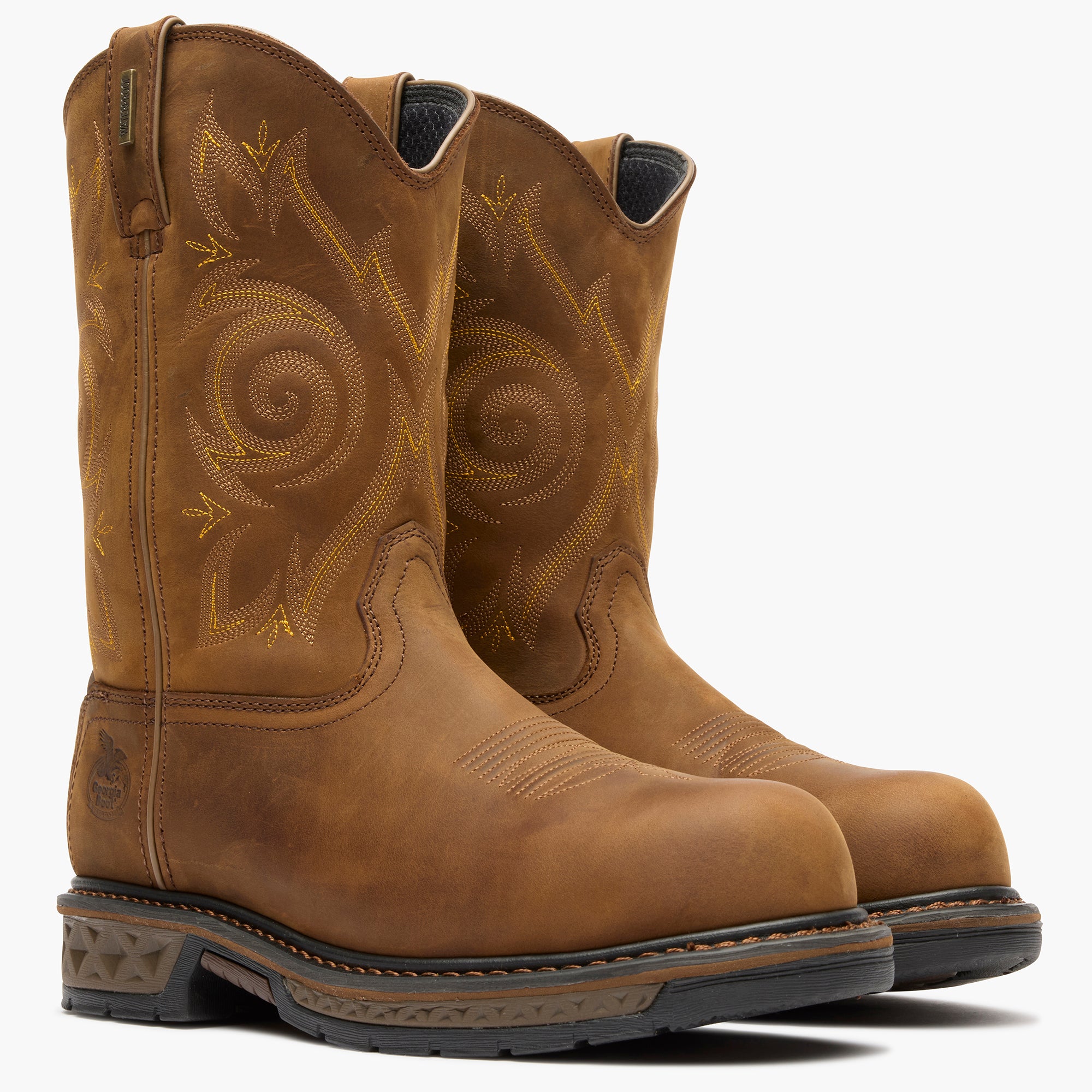 Pair of brown leather boots with intricate designs on a white background