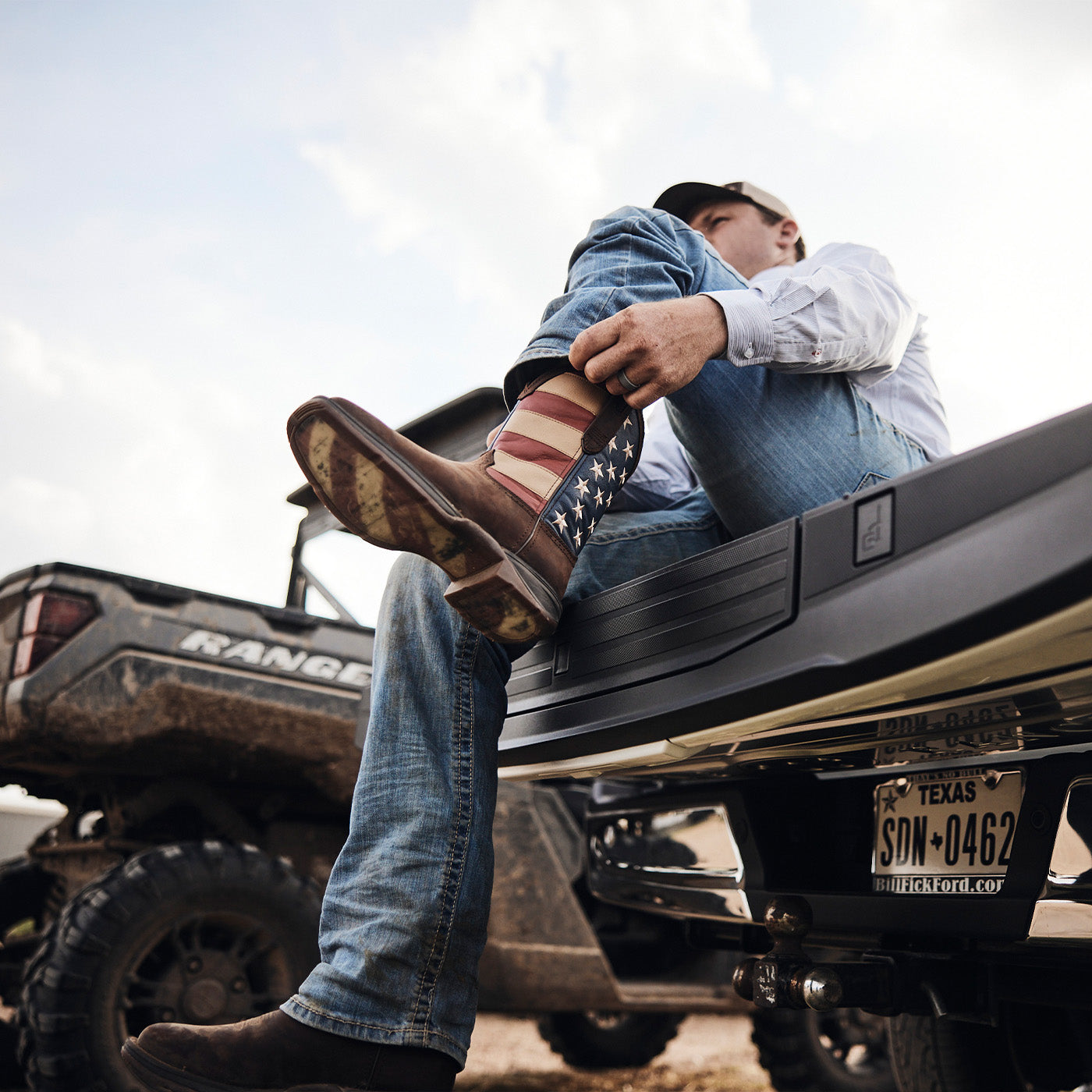 Man pulling on Durango's flag boot on the edge of a truck bed