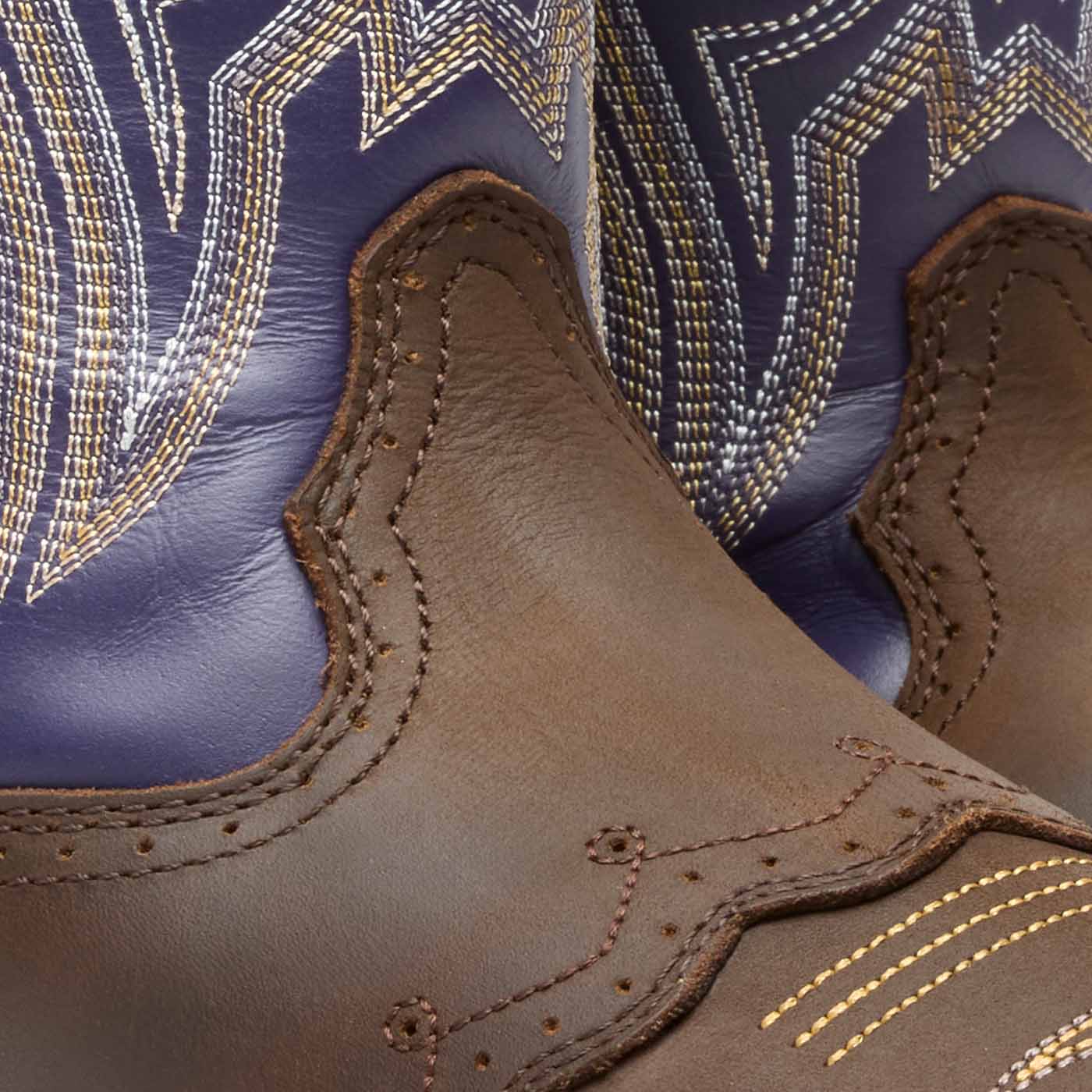 Close-up of brown leather Durango boot with purple shaft and intricate stitching details